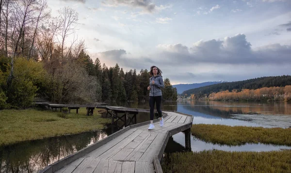 Caucasian Athletic Woman running on a Wooden Path across a swamp in Shoreline Trail — Fotografia de Stock