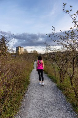 Shoreline Trail 'de Yeşil ağaçlarla Bir Yolda Yürüyen Kadın