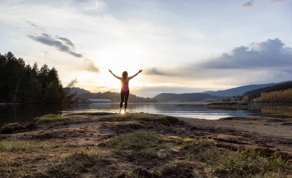 Sahildeki maceraperest kadın renkli günbatımının tadını çıkarıyor..