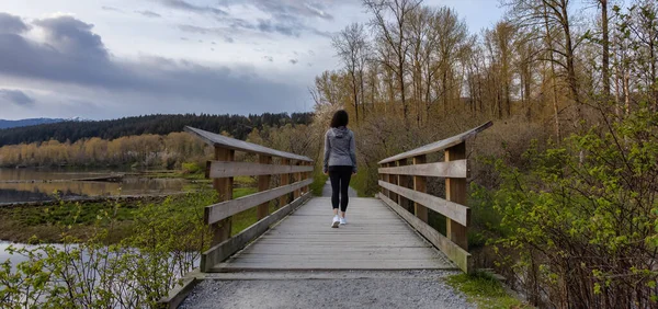 Woman Walking on a Wooden Path with green trees in Shoreline Trail — Fotografia de Stock