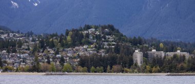 Arka planda dağ manzaralı modern bir şehirde ikamet eden evler.