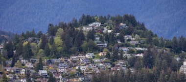 Arka planda dağ manzaralı modern bir şehirde ikamet eden evler.