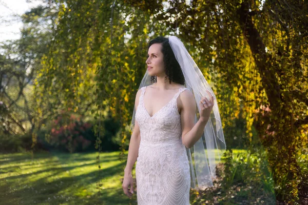 Vit kaukasisk vuxen kvinna i en bröllopsklänning står utanför i naturen — Stockfoto