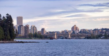 Modern Şehir, Stanley Park, Binalar, Plaj ve Pasifik Okyanusu 'nun batı kıyısındaki False Creek' teki Burrard Köprüsü. Vancouver şehir merkezi, British Columbia, Kanada. Panoramik Manzara. Günbatımı Gökyüzü
