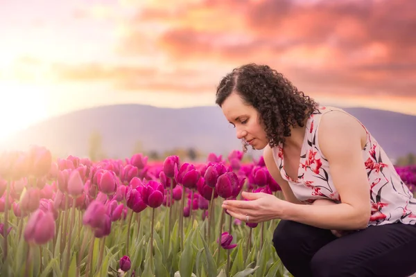 白人成人女性フィールドで新鮮なチューリップの花の香り 春シーズン アートレンダリング 日没または日の出空 — ストック写真