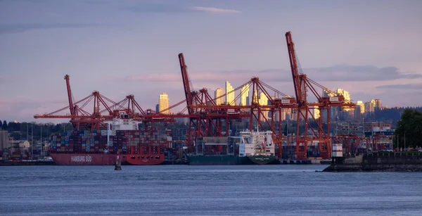 Downtown Vancouver, British Columbia, Canada - May 7, 2022: Panoramic View of Port in a modern city during cloudy colorful sunset.