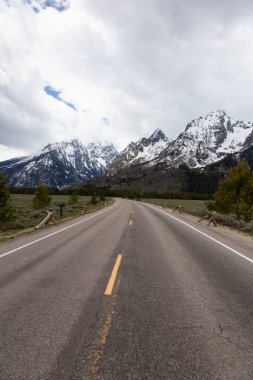 Manzaralı Yol ve Amerikan Peyzajı 'ndaki Kar Dağları. Bahar sezonu. Grand Teton Ulusal Parkı. Wyoming, Birleşik Devletler. Doğa Arkaplanı.