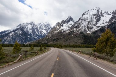 Manzaralı Yol ve Amerikan Peyzajı 'ndaki Kar Dağları. Bahar sezonu. Grand Teton Ulusal Parkı. Wyoming, Birleşik Devletler. Doğa Arkaplanı.