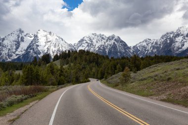 Manzaralı Yol, Amerika 'da dağlar ve ağaçlarla çevrili. Bahar sezonu. Grand Teton Ulusal Parkı. Wyoming, Birleşik Devletler. Doğa Arkaplanı.