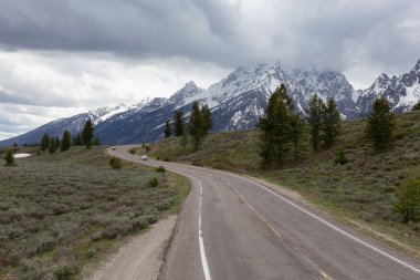 Scenic Road surrounded by Mountains in American Landscape. Spring Season. Grand Teton National Park. Wyoming, United States. Nature Background.
