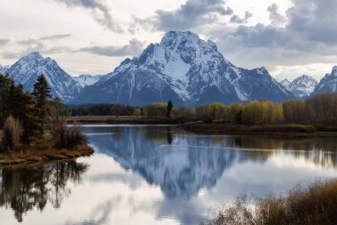 Amerika 'da ağaçlar ve dağlarla çevrili bir nehir. Snake River, Oxbow Bend. Bahar sezonu. Grand Teton Ulusal Parkı. Wyoming, Birleşik Devletler. Doğa Arkaplanı.