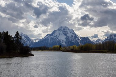Amerika 'da ağaçlar ve dağlarla çevrili bir nehir. Snake River, Oxbow Bend. Bahar sezonu. Grand Teton Ulusal Parkı. Wyoming, Birleşik Devletler. Doğa Arkaplanı.