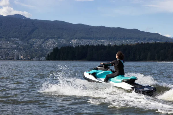Avontuurlijke Blanke Vrouw Waterscooter Rijden Oceaan Moderne Stad Bergen Achtergrond — Stockfoto