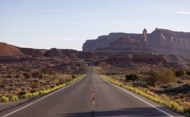 Scenic Road in the Dry Desert with Red Rocky Mountains in Background. Oljato-Monument Valley, Utah, United States.