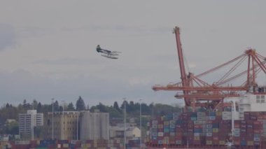 Downtown Vancouver, British Columbia, Canada - May 7, 2022: Panoramic View of Port in a modern city during cloudy colorful sunset. Airplane Landing