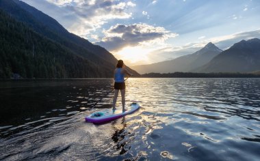 Maceracı Kadın Kanada Dağları 'nın etrafındaki bir gölde yüzüyor. Chilliwack Gölü, British Columbia, Kanada. Macera Spor Seyahati