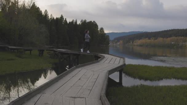 Woman Running Wooden Path Green Trees Shoreline Trail Port Moody — Vídeo de Stock