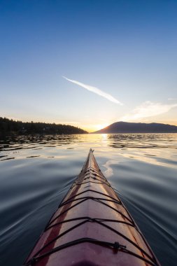 Pasifik Okyanusu 'nda deniz kanosu kürek çekiyor. Renkli Günbatımı Gökyüzü. Victoria, Vancouver Adaları, British Columbia, Kanada yakınlarında çekilmiş. Konsept: Spor, Macera