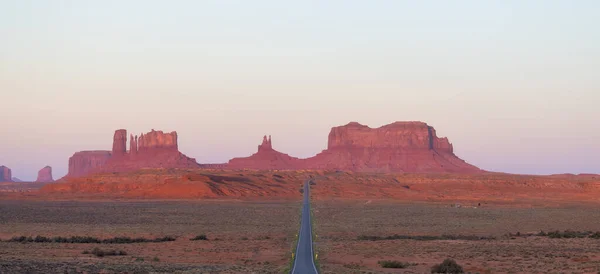 Scenic Road in the Dry Desert with Red Rocky Mountains in Background. Sunrise Sky. Forrest Gump Point in Oljato-Monument Valley, Utah, United States. Panorama