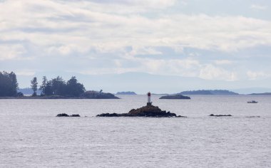 Rocky Island with Lighthouse, Ocean and surrounding Islands with Trees on Cloudy Day. Summer Season. Near Nanaimo., Vancouver Island, British Columbia, Canada. Nature Background.