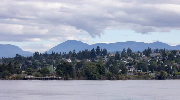 Homes by the water, surrounded by tees and mountains. Summer Season. Nanaimo, Vancouver Island, British Columbia, Canada. City Background.