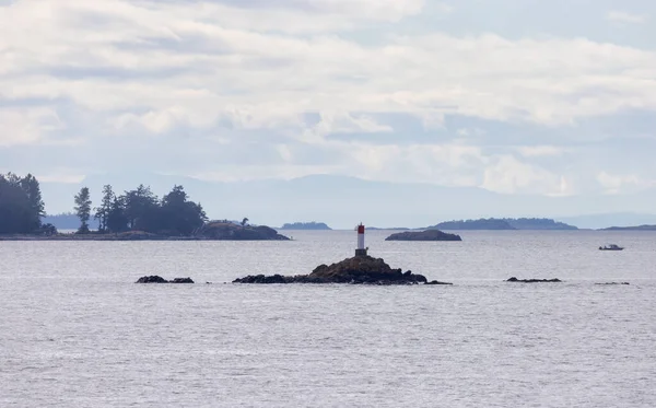 Rocky Island with Lighthouse, Ocean and surrounding Islands with Trees on Cloudy Day. Summer Season. Near Nanaimo., Vancouver Island, British Columbia, Canada. Nature Background.