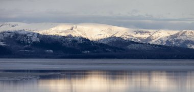 View of a frozen Yellowstone Lake with snow covered mountains in American Landscape. Yellowstone National Park. United States. Nature Background.
