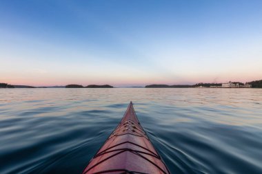 Pasifik Okyanusu 'nda deniz kanosu kürek çekiyor. Renkli Günbatımı Gökyüzü. Victoria, Vancouver Adaları, British Columbia, Kanada yakınlarında çekilmiş. Konsept: Spor, Macera