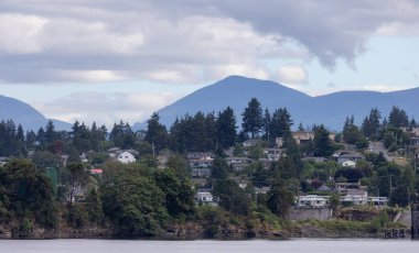 Homes by the water, surrounded by tees and mountains. Summer Season. Nanaimo, Vancouver Island, British Columbia, Canada. City Background.