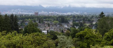 Residential Homes, Modern City and Mountain Landscape. View from Queen Elizabeth Park, Vancouver, British Columbia, Canada.