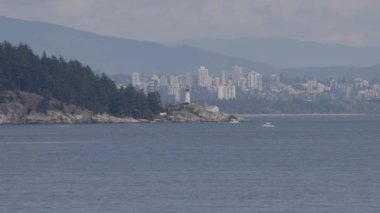 Lighthouse Park, Modern city in background during sunny summer day. West Vancouver, British Columbia, Canada. Slow Motion