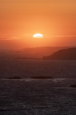 Waves on the Pacific Ocean on a rocky beach. West Coast. Sunny Summer Sunset. Cox Bay, Tofino, Vancouver Island, BC, Canada. Canadian Nature Background.