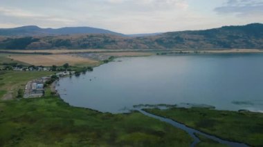 Aerial View of Okanagan Lake with farm lands and mountain landscape. Cloudy Sunset Sky. Near Vernon, British Columbia, Canada.