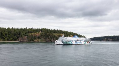 Galiano Island, British Columbia, Canada - June 22, 2022: BC Ferries Boat in Pacific Ocean during cloudy summer day.
