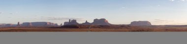 Scenic Road in the Dry Desert with Red Rocky Mountains in Background. Oljato-Monument Valley, Utah, United States. Panorama. Sunset Sky