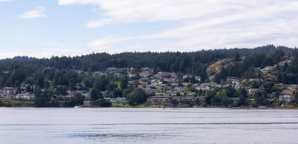 Homes by the water, surrounded by tees and mountains. Summer Season. Nanaimo, Vancouver Island, British Columbia, Canada. City Background.