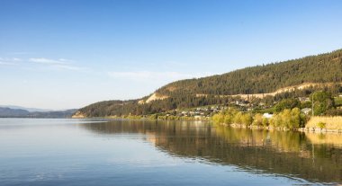 Peaceful View of Wood Lake with Reflection on the water and mountains in background. Lake Country, Okanagan, British Columbia, Canada. Sunrise