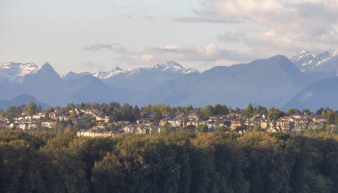 Residential Homes in a modern city with mountain peaks in background. Mary Hill, Port Coquitlam, Vancouver, British Columbia, Canada.