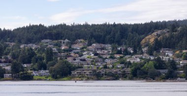 Homes by the water, surrounded by tees and mountains. Summer Season. Nanaimo, Vancouver Island, British Columbia, Canada. City Background.