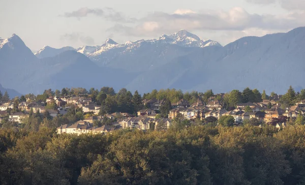 Residential Homes in a modern city with mountain peaks in background. Mary Hill, Port Coquitlam, Vancouver, British Columbia, Canada.