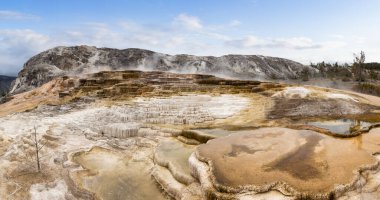 Amerikan Peyzajı 'nda renkli suyla sıcak kaynak gayzeri. Bulutlu Gök Sanatı Hazırlama. Yellowstone Ulusal Parkı, Wyoming, ABD. Doğa Arkaplan Panoraması