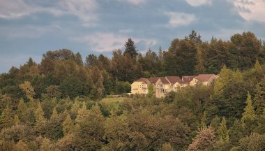 Residential Homes on top of a hill surrounded by green trees. Cloudy Sky Sunset. Fraser Heights, Surrey, Vancouver, BC, Canada.