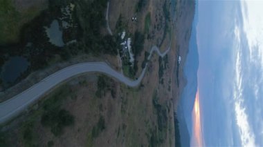 Aerial View of a Scenic Road in the Desert during colorful cloudy sunrise. Near Vernon, Okanagan, British Columbia, Canada. Vertical Portrait Video