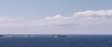 Rugged Rocks on a rocky shore on the West Coast of Pacific Ocean. Summer Morning Sky. Ucluelet, Vancouver Island, British Columbia, Canada. Nature Background