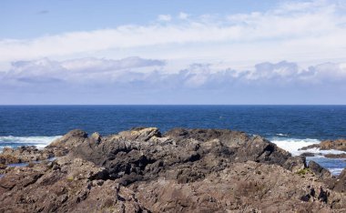 Rugged Rocks on a rocky shore on the West Coast of Pacific Ocean. Summer Morning Sky. Ucluelet, Vancouver Island, British Columbia, Canada. Nature Background
