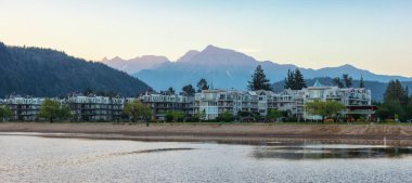 Vacation Homes by the lake and sandy beach. Sunny Summer Morning Sunrise Sky. Harrison Hot Springs, British Columbia, Canada.