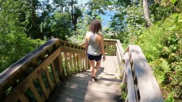 在阳光明媚的夏日 妇女在绿树成荫的森林里走木径 加拿大不列颠哥伦比亚省大温哥华白岩的1001级台阶 — 图库视频影像