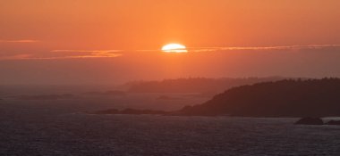 Waves on the Pacific Ocean on a rocky beach. West Coast. Sunny Summer Sunset. Cox Bay, Tofino, Vancouver Island, BC, Canada. Canadian Nature Background.