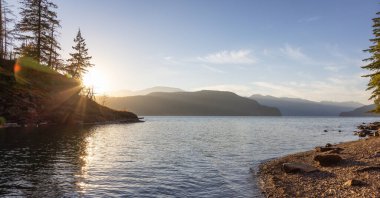 Ağaçları ve gölü olan Kanada Dağ manzarası. Güneşli Yaz Günbatımı Gökyüzü. Harrison Kaplıcaları, British Columbia, Kanada. Doğa Arkaplanı