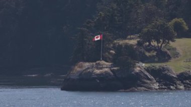 Canadian Flag and Landscape by the ocean. Summer Season. Gulf Islands near Vancouver Island, British Columbia, Canada. Canadian Landscape.